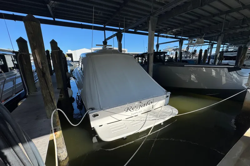 Slide: The Image of 2013 Cabo 44 Hardtop Express docked in marina, covered and secured. - 23