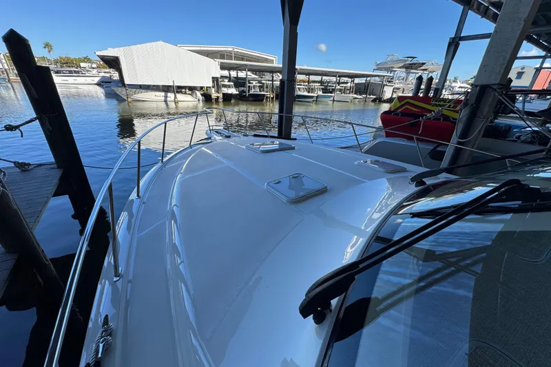 Slide: The Image of 2013 Cabo 44 Hardtop Express yacht docked at marina under clear blue sky. - 26
