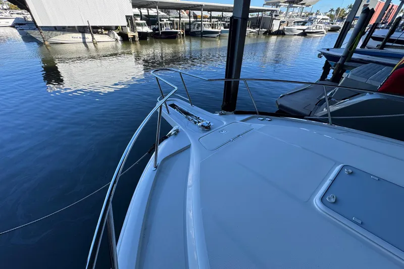 Slide: The Image of 2013 Cabo 44 Hardtop Express yacht docked at marina, showcasing sleek bow design. - 27