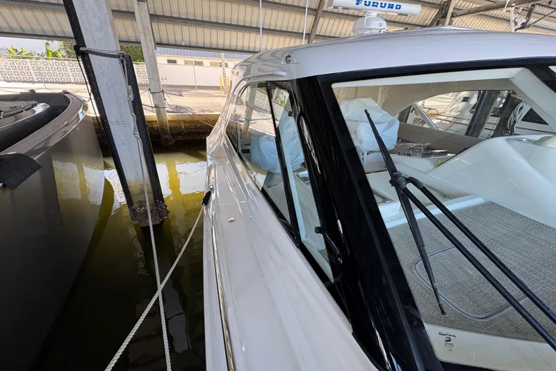 Slide: The Image of 2013 Cabo 44 Hardtop Express yacht docked in a marina, side view. - 30