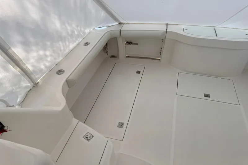 Slide: The Image of 2013 Cabo 44 Hardtop Express boat interior with white seating and storage compartments. - 39