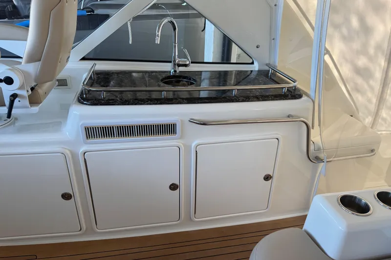 Slide: The Image of 2013 Cabo 44 Hardtop Express yacht interior with sink and storage cabinets. - 44