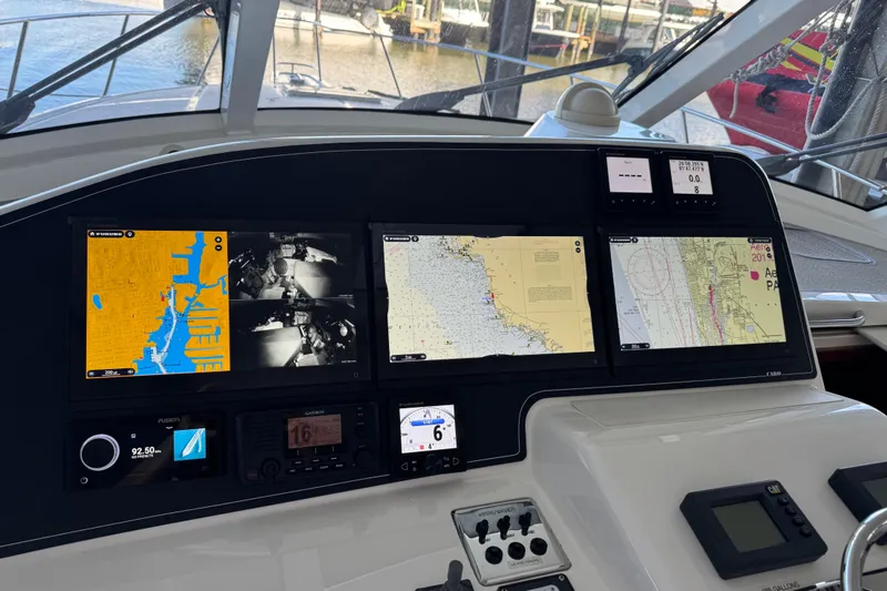 Slide: The Image of Helm of 2013 Cabo 44 Hardtop Express with navigation screens and controls. - 56