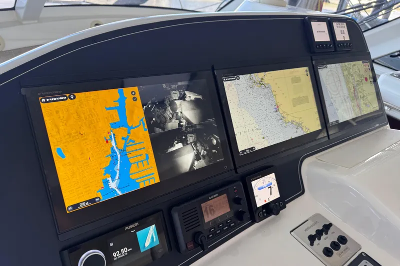 Slide: The Image of Navigation dashboard of a 2013 Cabo 44 Hardtop Express boat with multiple screens. - 58