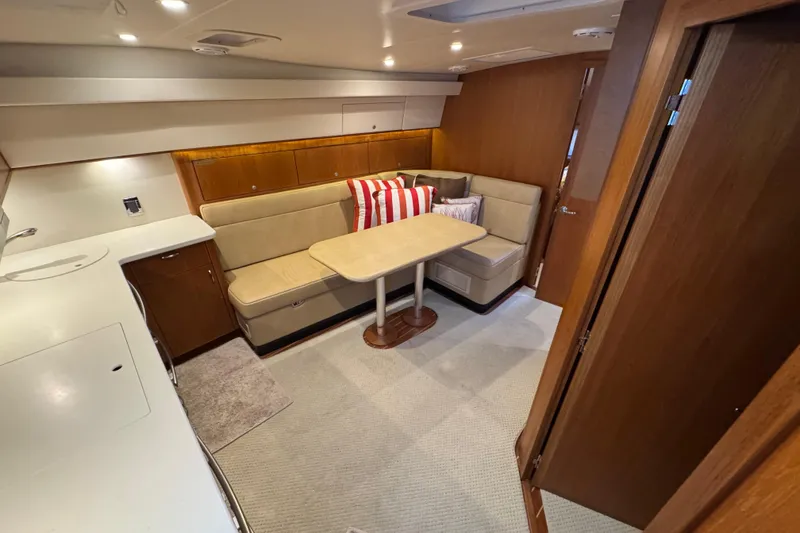 Slide: The Image of 2013 Cabo 44 Hardtop Express interior with cozy seating and dining area. - 60