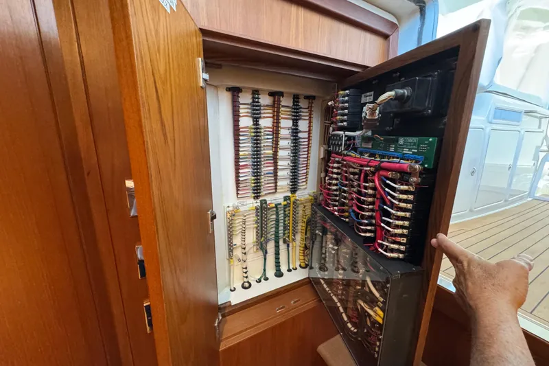Slide: The Image of Electrical panel inside 2013 Cabo 44 Hardtop Express yacht, showcasing wiring and components. - 65