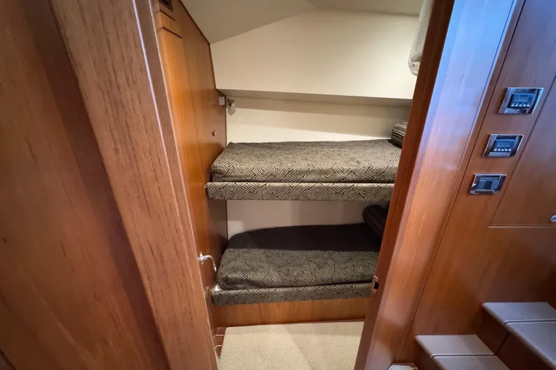 Slide: The Image of Interior of 2013 Cabo 44 Hardtop Express with cozy bunk beds and wooden paneling. - 67