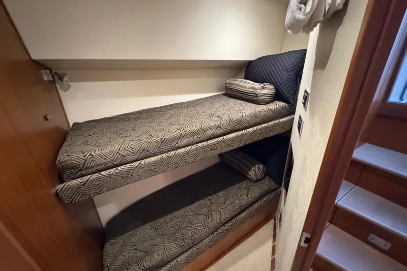 Slide: The Image of 2013 Cabo 44 Hardtop Express cabin with bunk beds and patterned bedding. - 68