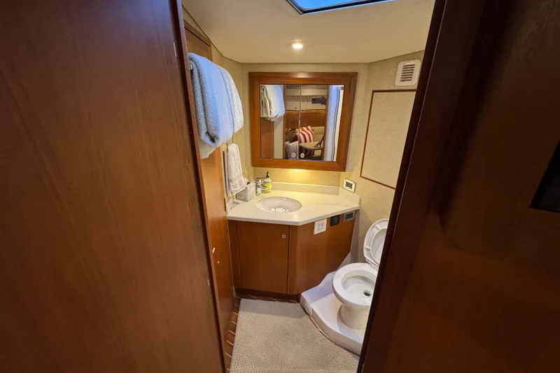 Slide: The Image of Luxurious bathroom in 2013 Cabo 44 Hardtop Express yacht, featuring wood accents and modern amenities. - 70