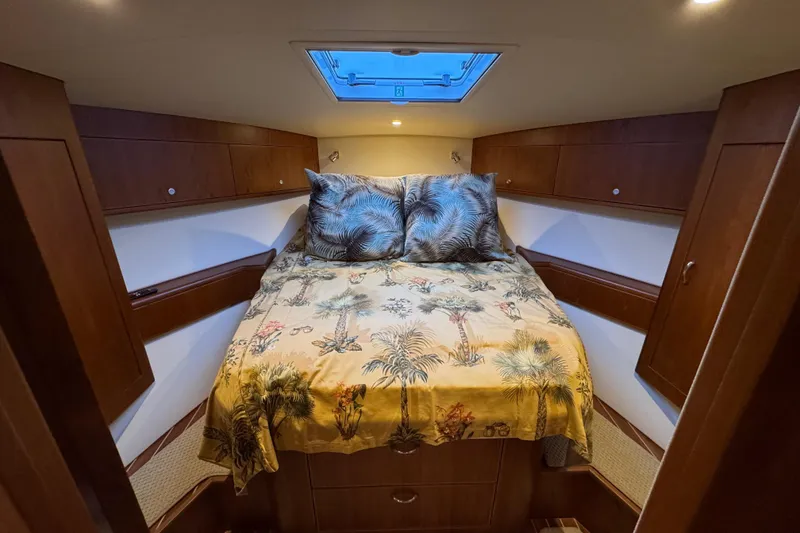 Slide: The Image of Luxurious cabin interior of 2013 Cabo 44 Hardtop Express with cozy bedding and wood finish. - 72