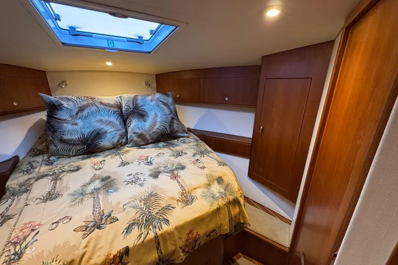 Slide: The Image of 2013 Cabo 44 Hardtop Express cabin with cozy bed and tropical decor. - 74