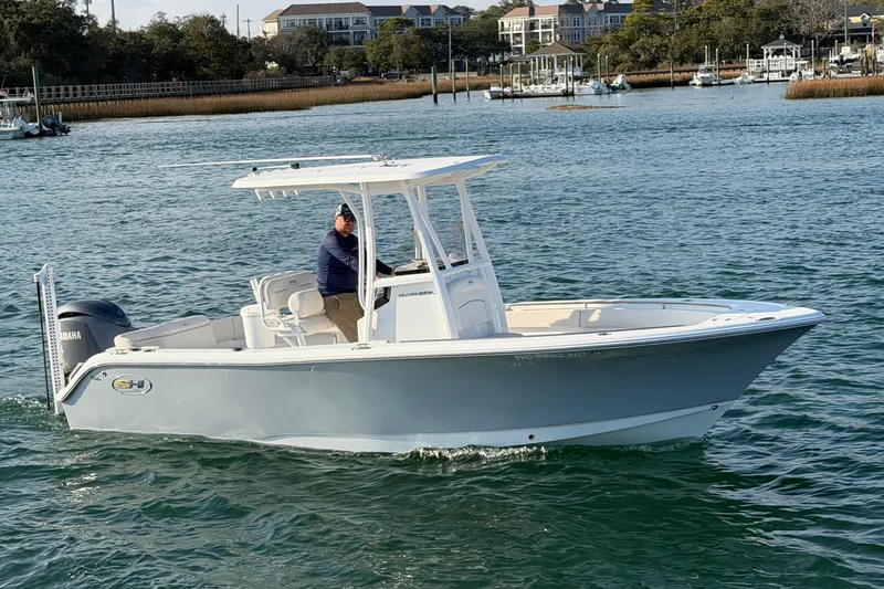 Slide: The Image of 2025 Sea Hunt Ultra 229 boat cruising on a calm waterway. - 10