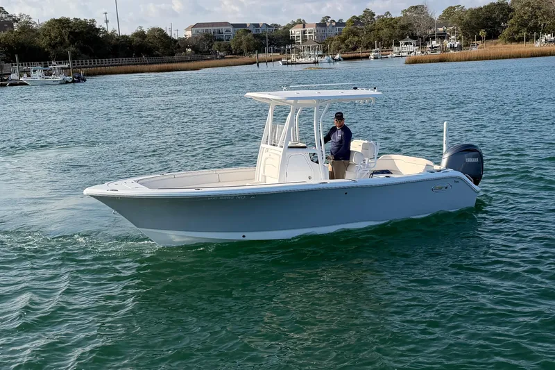 Slide: The Image of 2025 Sea Hunt Ultra 229 boat on water with a person onboard. - 2