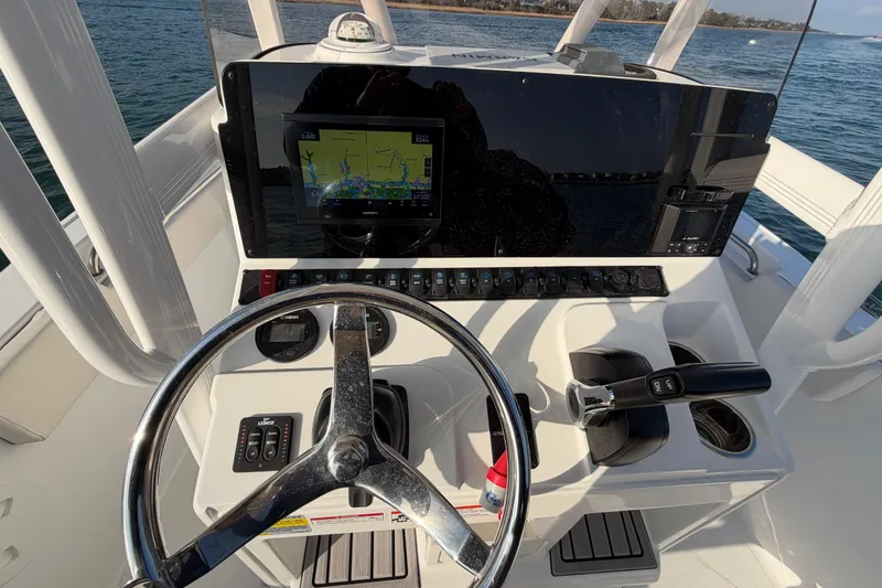 Slide: The Image of Cockpit of 2025 Sea Hunt Ultra 229 boat with steering wheel and navigation display. - 24