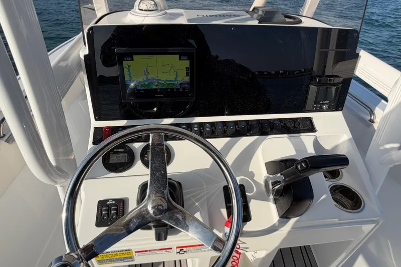 Slide: The Image of 2025 Sea Hunt Ultra 229 boat dashboard with steering wheel and navigation display. - 25