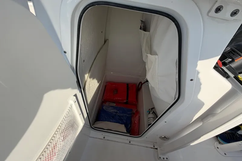 Slide: The Image of Storage compartment in 2025 Sea Hunt Ultra 229 boat, featuring safety equipment and gear. - 28