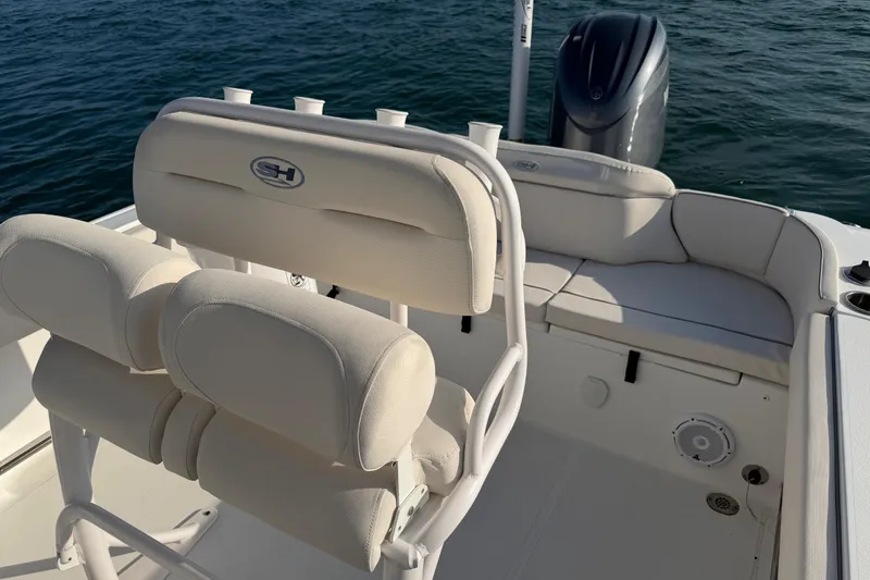 Slide: The Image of 2025 Sea Hunt Ultra 229 boat interior with cushioned seating and ocean backdrop. - 31