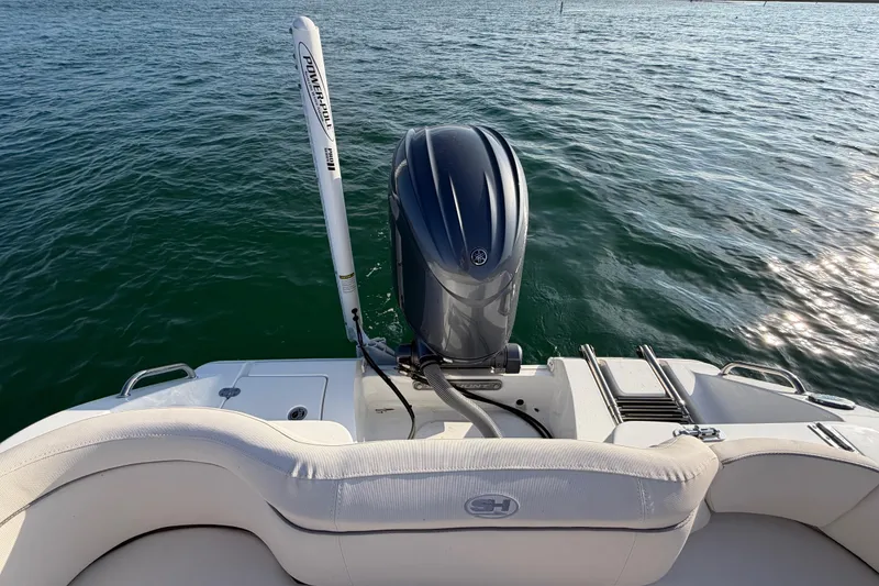 Slide: The Image of 2025 Sea Hunt Ultra 229 boat with outboard motor on calm water. - 35