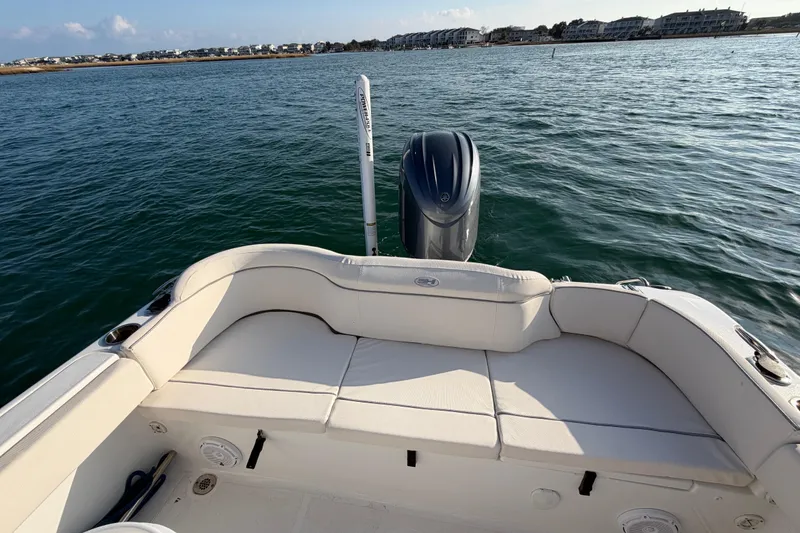 Slide: The Image of 2025 Sea Hunt Ultra 229 boat with cushioned seating, on calm water. - 36