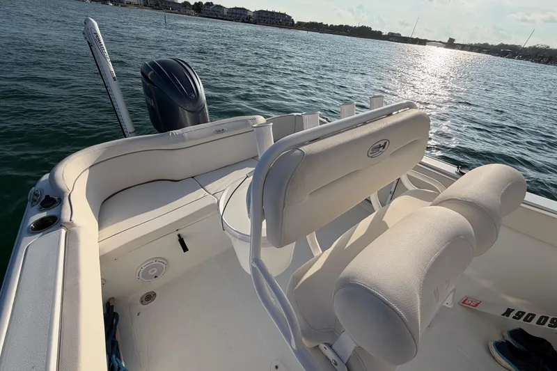 Slide: The Image of 2025 Sea Hunt Ultra 229 boat interior with seating, on a sunny day at sea. - 38