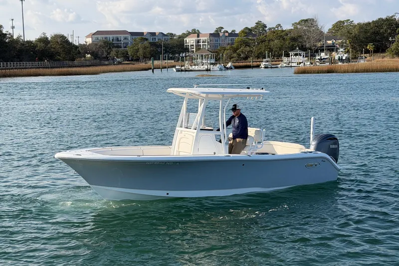 Slide: The Image of 2025 Sea Hunt Ultra 229 boat on calm water with scenic background. - 4