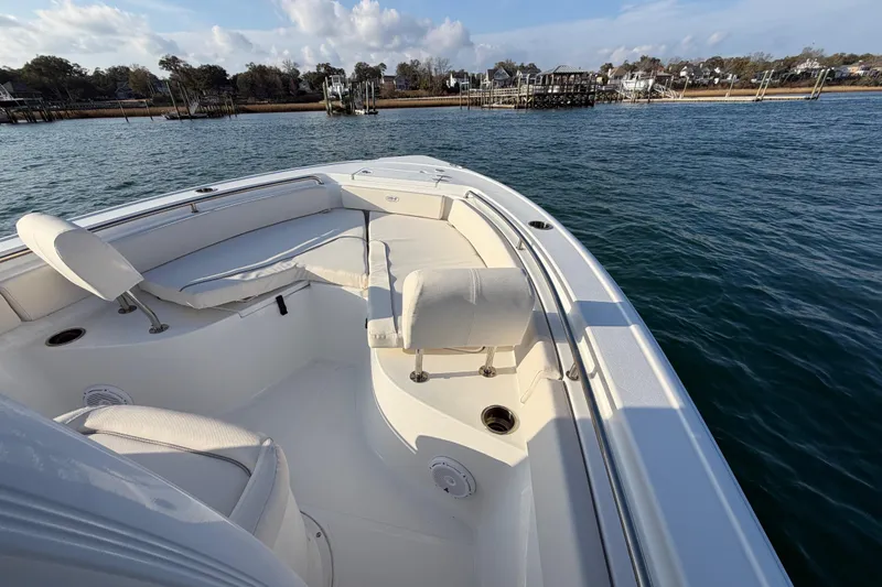 Slide: The Image of 2025 Sea Hunt Ultra 229 boat on calm water, featuring spacious seating and scenic shoreline. - 41