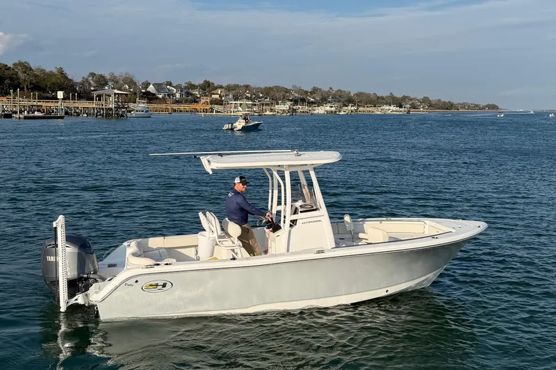 Slide: The Image of 2025 Sea Hunt Ultra 229 boat cruising on a scenic coastal waterway. - 47