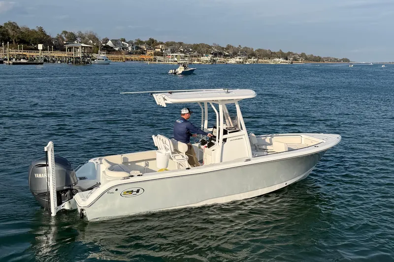 Slide: The Image of 2025 Sea Hunt Ultra 229 boat on calm water, featuring a Yamaha outboard motor. - 49