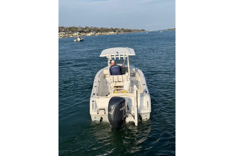 Slide: The Image of 2025 Sea Hunt Ultra 229 boat on water, rear view with Yamaha engine. - 51