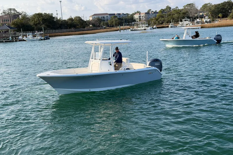 Slide: The Image of 2025 Sea Hunt Ultra 229 boat cruising on a scenic waterway. - 9