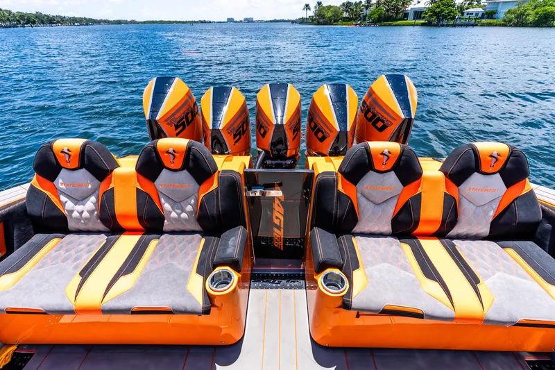 Slide: The Image of Luxury 2025 Statement 44 GRTS boat with vibrant orange seating and powerful engines on a serene lake. - 48