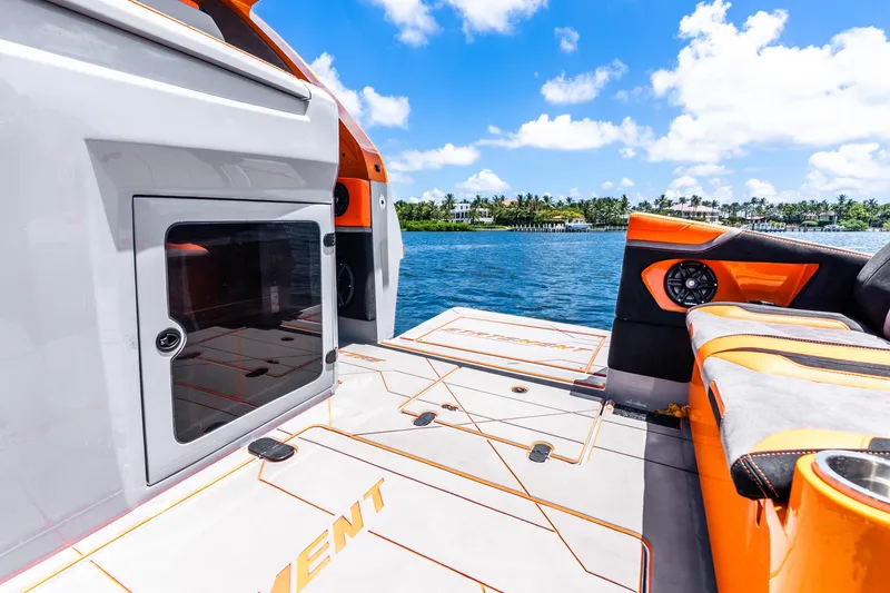 Slide: The Image of 2025 Statement 44 GRTS boat interior with orange accents, docked by a scenic waterfront. - 58