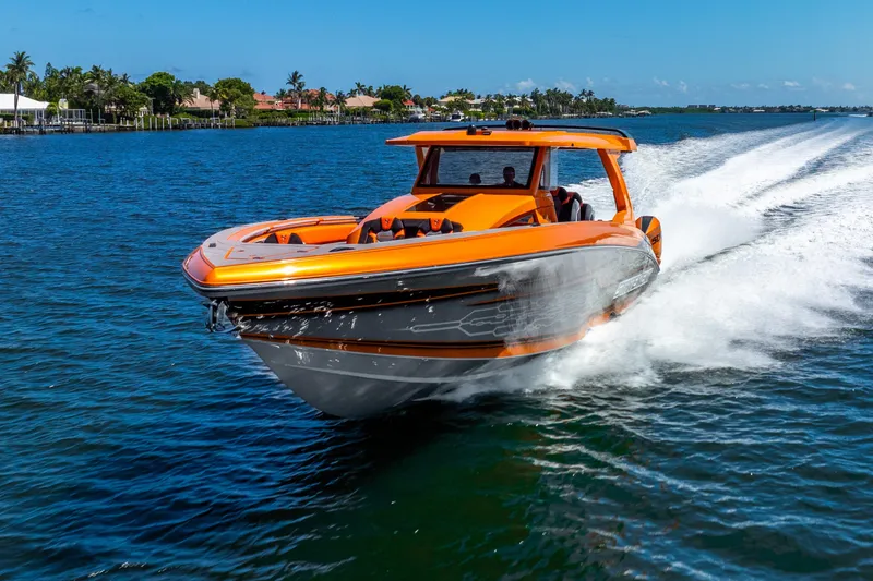Slide: The Image of Orange Statement 44 GRTS boat speeding on water, 2025 model, under clear blue sky. - 15