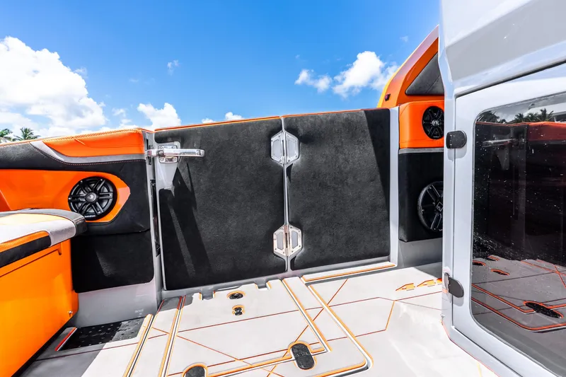 Slide: The Image of 2025 Statement 44 GRTS boat interior with vibrant orange and black design under clear blue sky. - 57