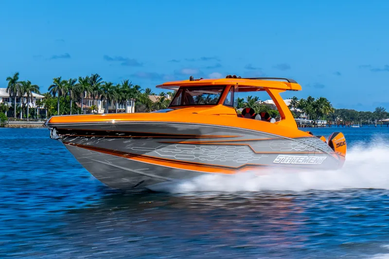 Slide: The Image of Orange Statement 44 GRTS boat cruising on water, 2025 model, with palm trees in the background. - 71