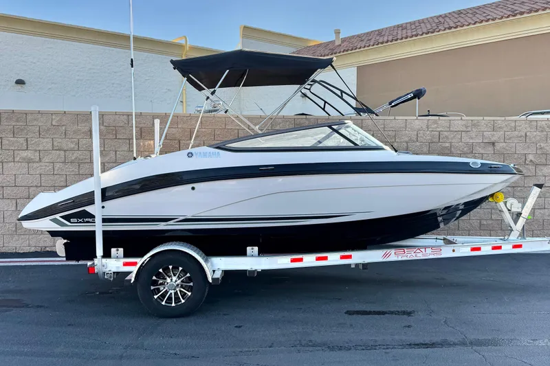 The Image of 2019 Yamaha Boats SX190 on trailer, parked outdoors, side view. - 0
