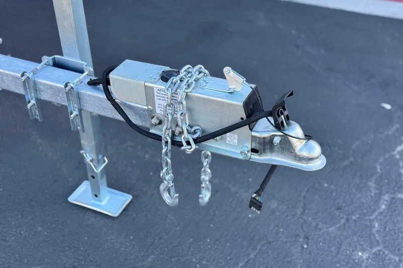 Slide: The Image of Trailer hitch with safety chains for 2019 Yamaha Boats SX190 on asphalt. - 29