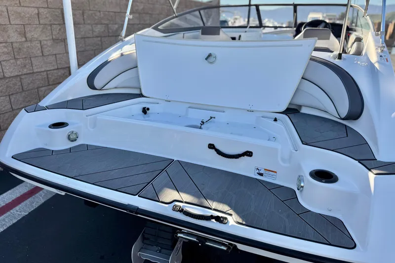Slide: The Image of 2019 Yamaha Boats SX190 rear view with open storage compartment and seating area. - 7