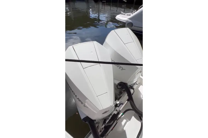 Slide: The Image of Twin Mercury outboard engines on a 2023 Schaefer 303 Sport boat, docked by the water. - 11