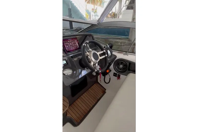 Slide: The Image of 2023 Schaefer 303 Sport boat interior with modern steering and dashboard. - 4