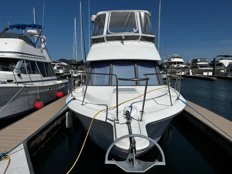 Slide: The Image of 1996 Carver 325 Aft Cabin yacht docked at marina under clear blue sky. - 1