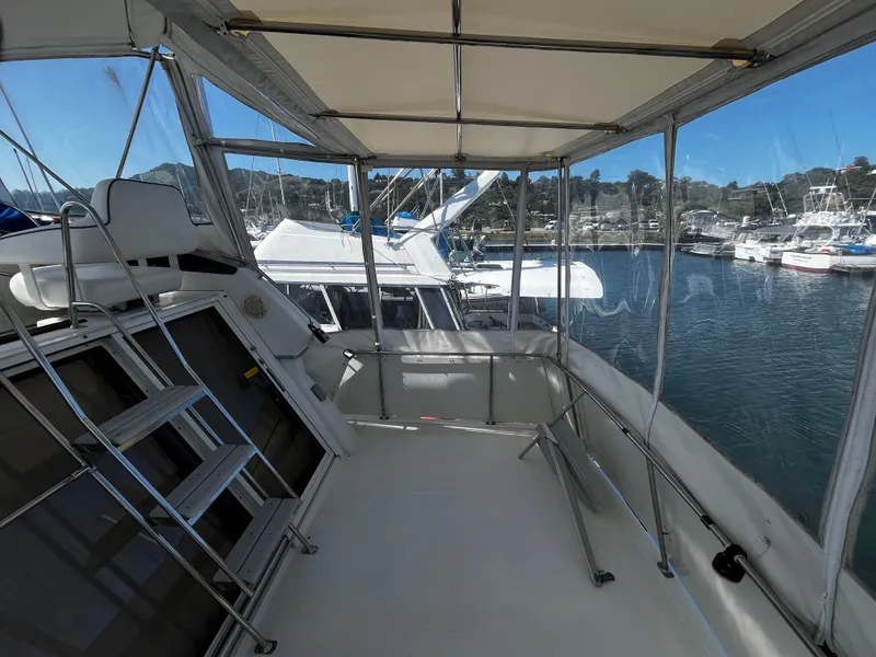 Slide: The Image of 1996 Carver 325 Aft Cabin boat interior with ladder and seating, docked in marina. - 12