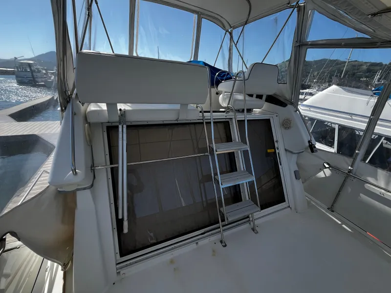 Slide: The Image of 1996 Carver 325 Aft Cabin helm with blue cover, docked at marina. - 13