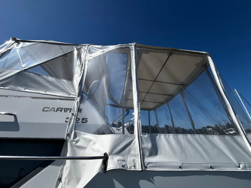 Slide: The Image of 1996 Carver 325 Aft Cabin yacht docked at marina under clear blue sky. - 5