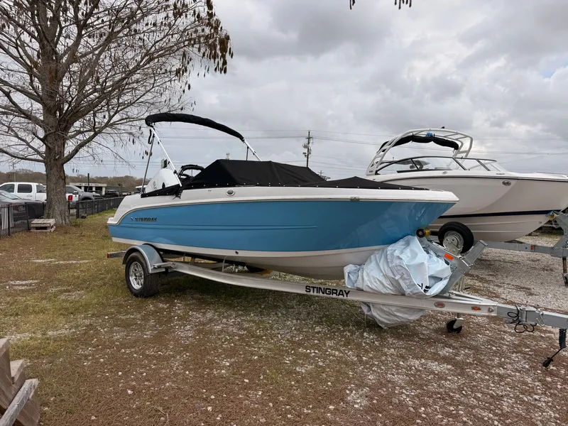Slide: The Image of Stingray 172 DC boat 2025 on trailer, blue, parked outdoors. - 48