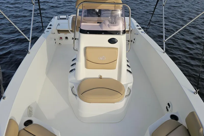 Slide: The Image of 2021 NauticStar 191 Hybrid boat interior with tan seating on water. - 17