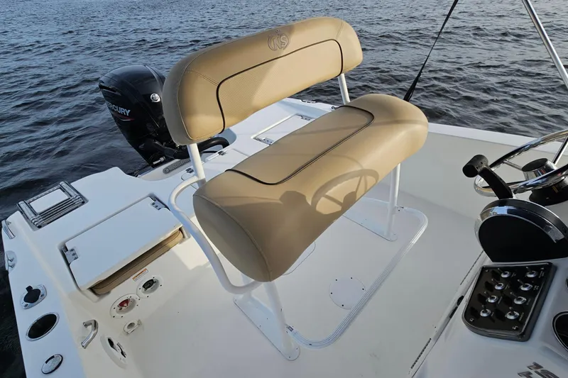 Slide: The Image of 2021 NauticStar 191 Hybrid boat interior with tan seating and Mercury engine on water. - 19