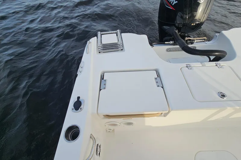 Slide: The Image of 2021 NauticStar 191 Hybrid boat stern with motor and swim ladder on water. - 20