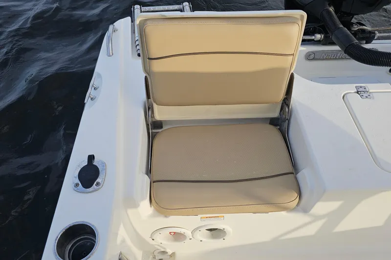 Slide: The Image of 2021 NauticStar 191 Hybrid boat seat with beige upholstery and water backdrop. - 23