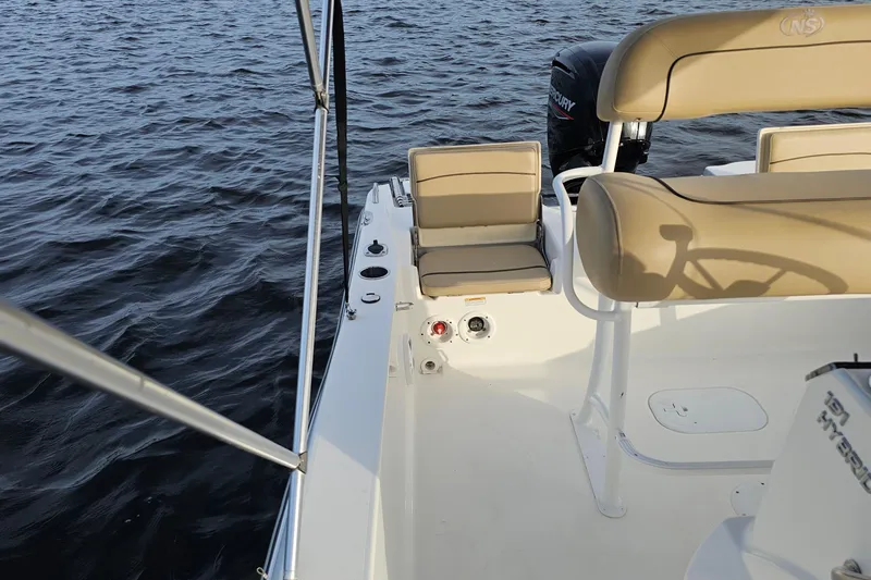 Slide: The Image of 2021 NauticStar 191 Hybrid boat interior with tan seating on calm water. - 25